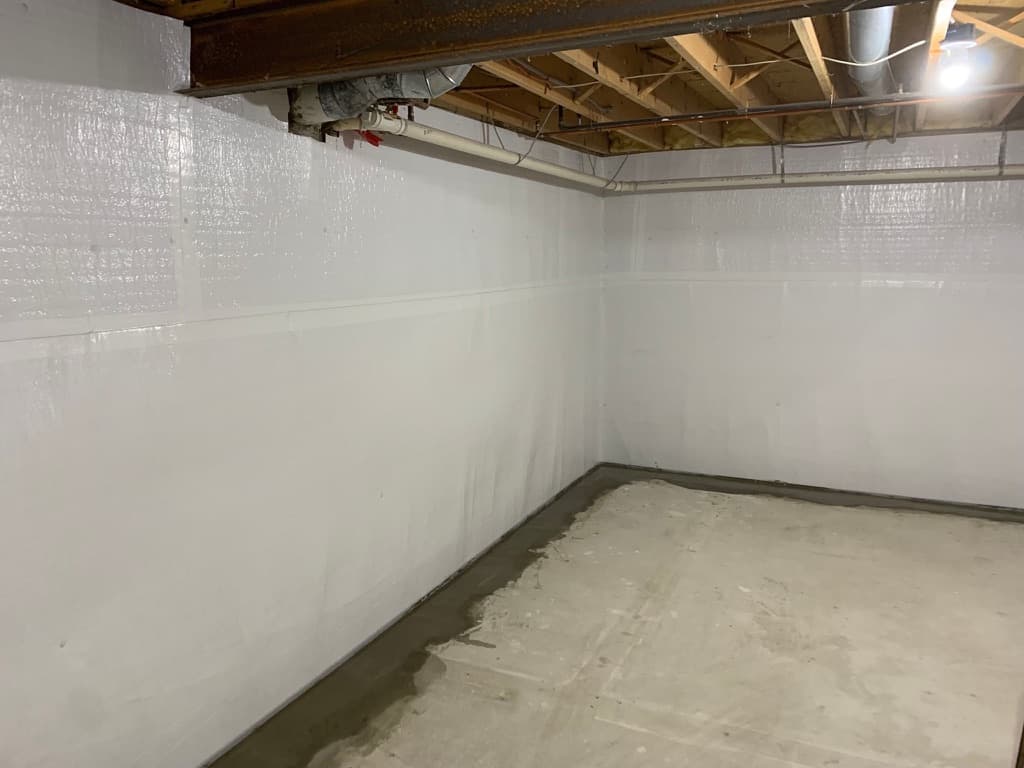 Quali-Dry interior perimeter drain install — sealed walls, fresh concrete cap